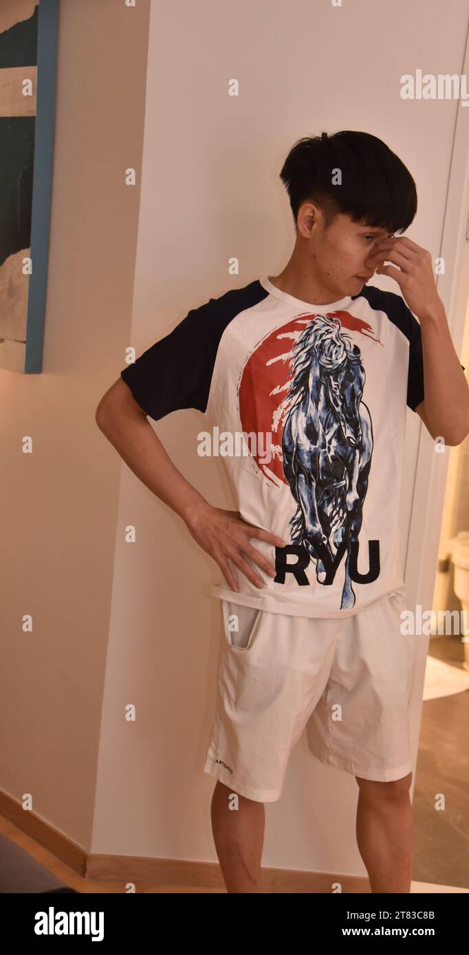 A handsome young, well dressed teenage, Asian boy or man, aged 18 to 24 ...