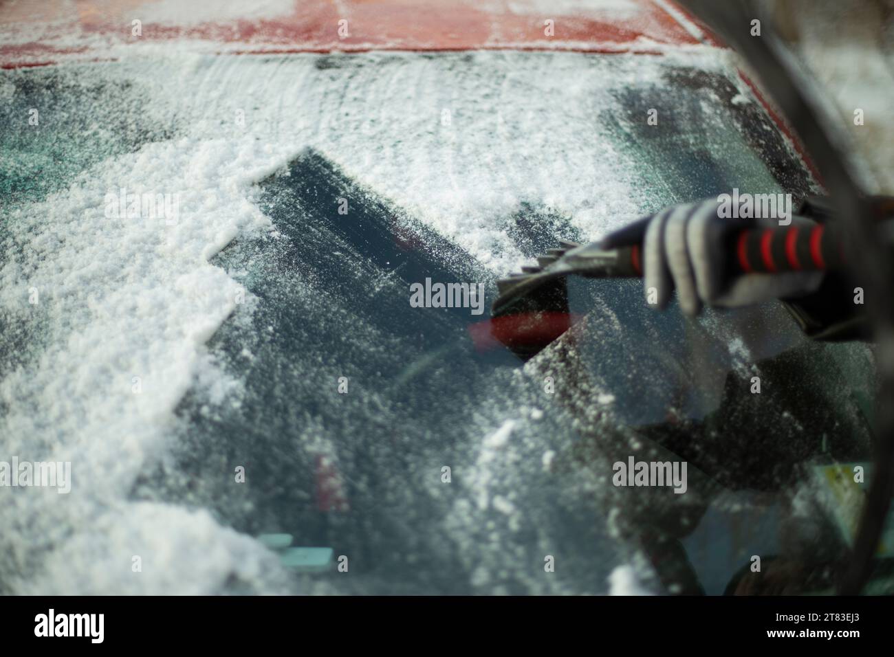 Cleaning glass from snow. Icy windshield. Snow removal. Scraping ice