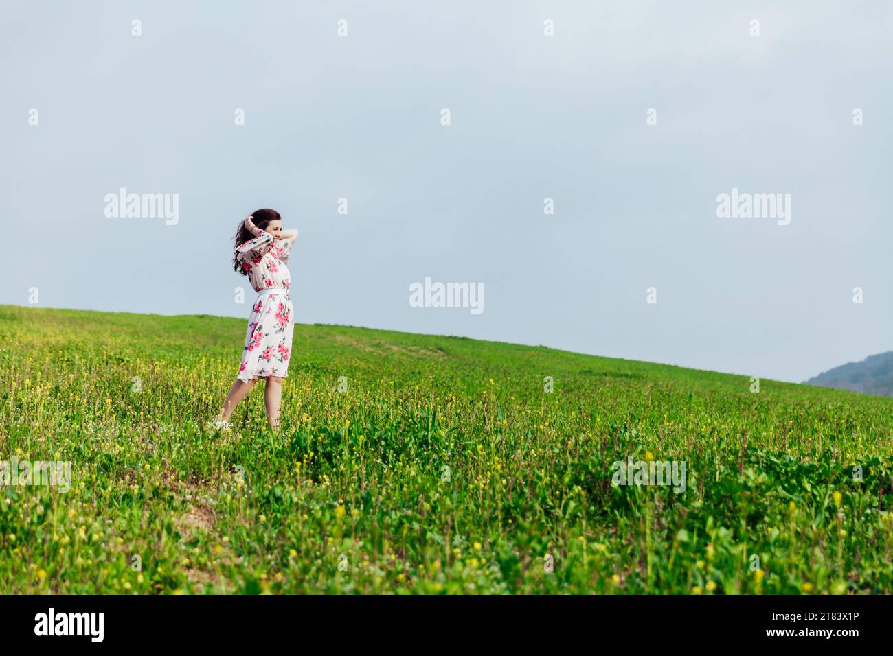 a beautiful woman stands in a green clearing in nature Stock Photo - Alamy