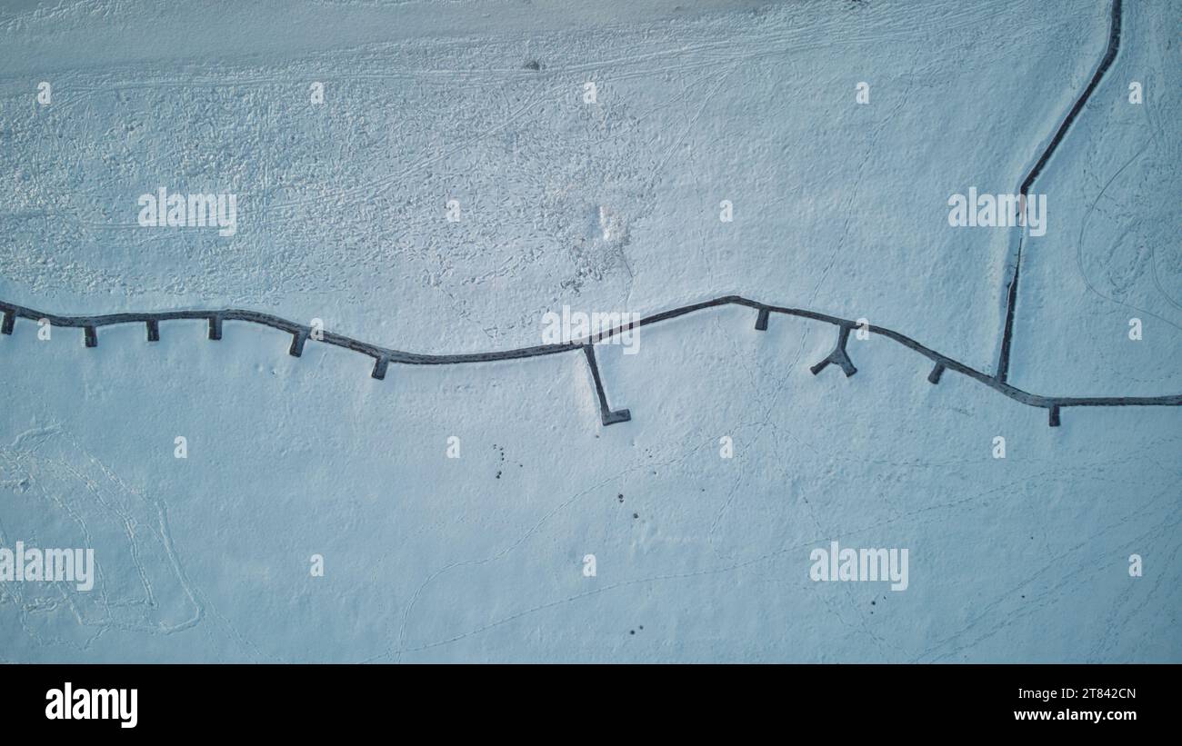 Snow-covered ground with natural patterns and footprints Stock Photo