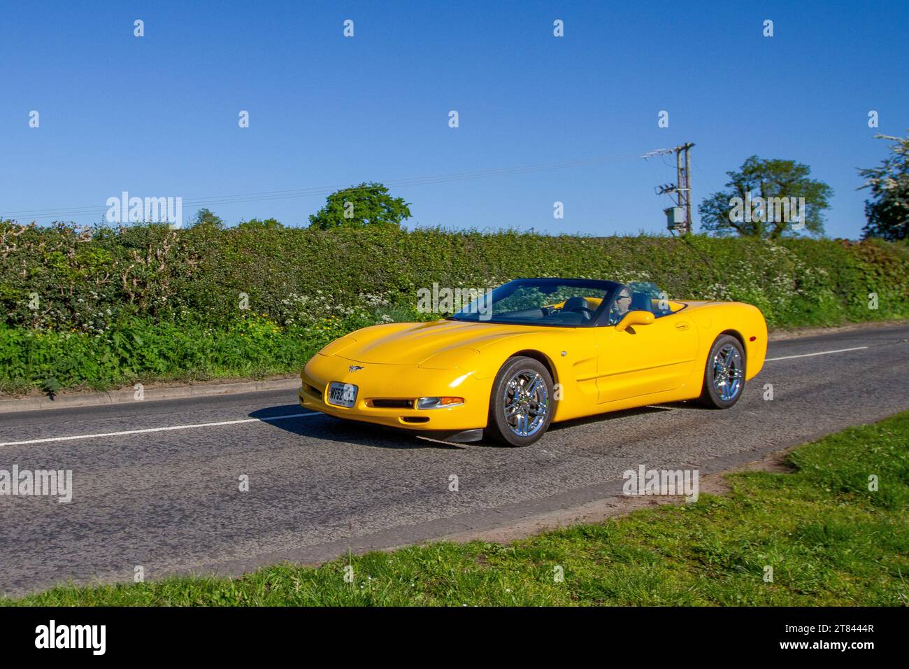 2003 Yellow American Chevrolet Gmc Corvette-2003 Chevy Corvette Convertible 6 Speed 2dr, two-door, two-seater luxury sports car; travelling on rural roads in Cheshire, UK Stock Photo