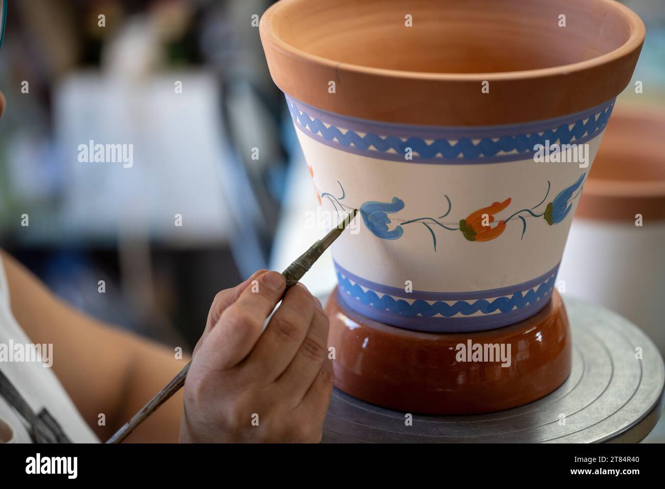 An artisan hand paints traditional Alentejo pottery at Olaria O Patalim ...