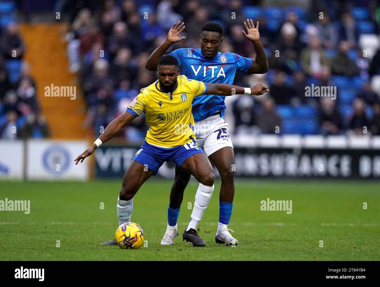 Colchester United's Mandela Egbo (left) and Stockport County's Isaac Olaofe battle for the ball during the Sky Bet League Two match at Edgeley Park, Stockport. Picture date: Saturday November 18, 2023. Stock Photo