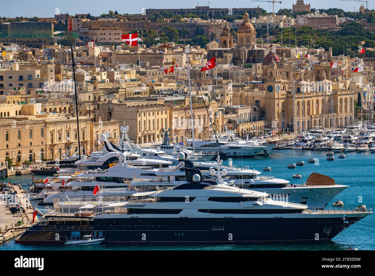 The calm waters and boats surrounding the Three Cities opposite Valletta in Malta Stock Photo