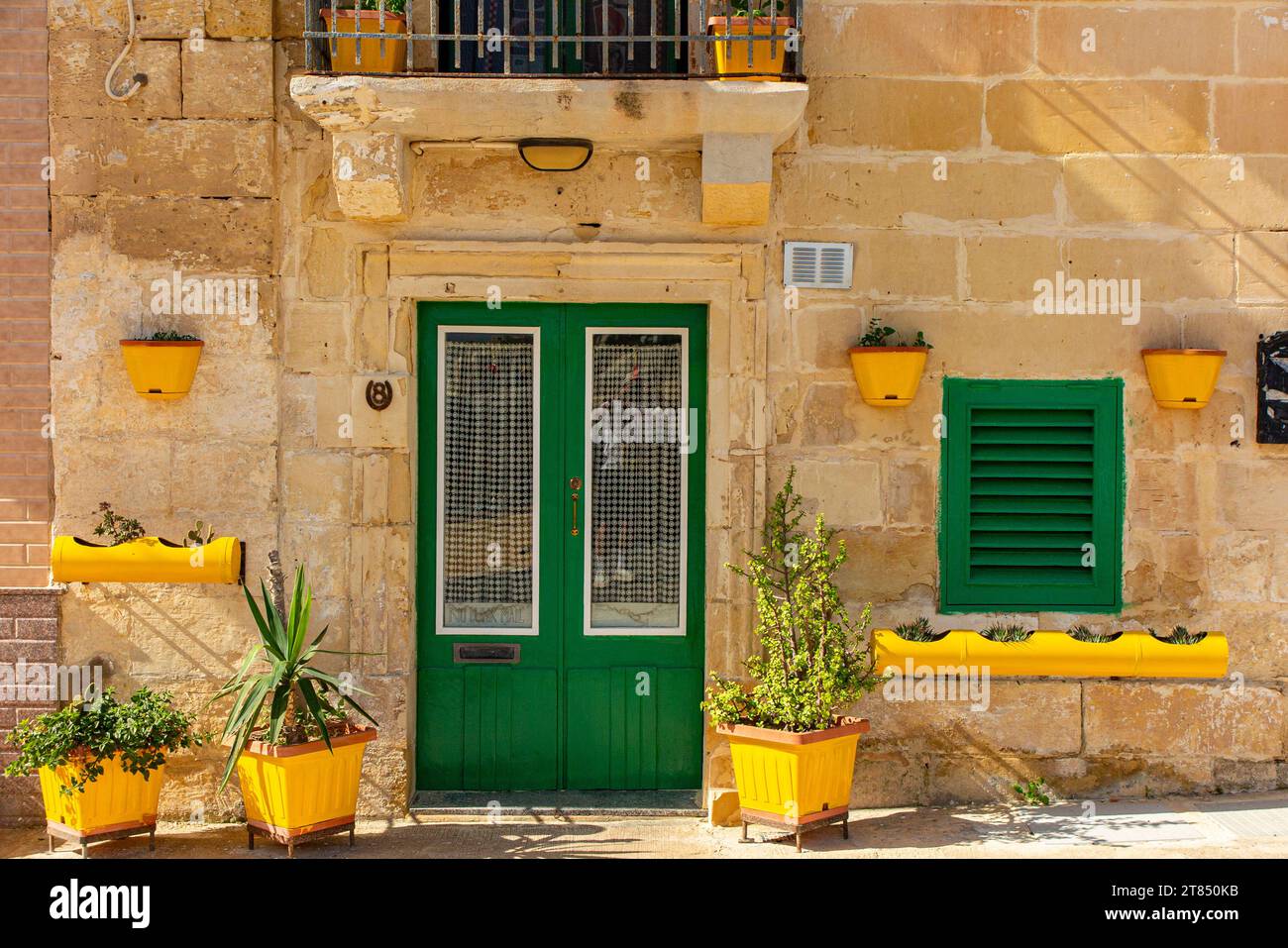 A pretty house with green and yellow facade in one of the Three Cities near Valletta, Malta. Stock Photo
