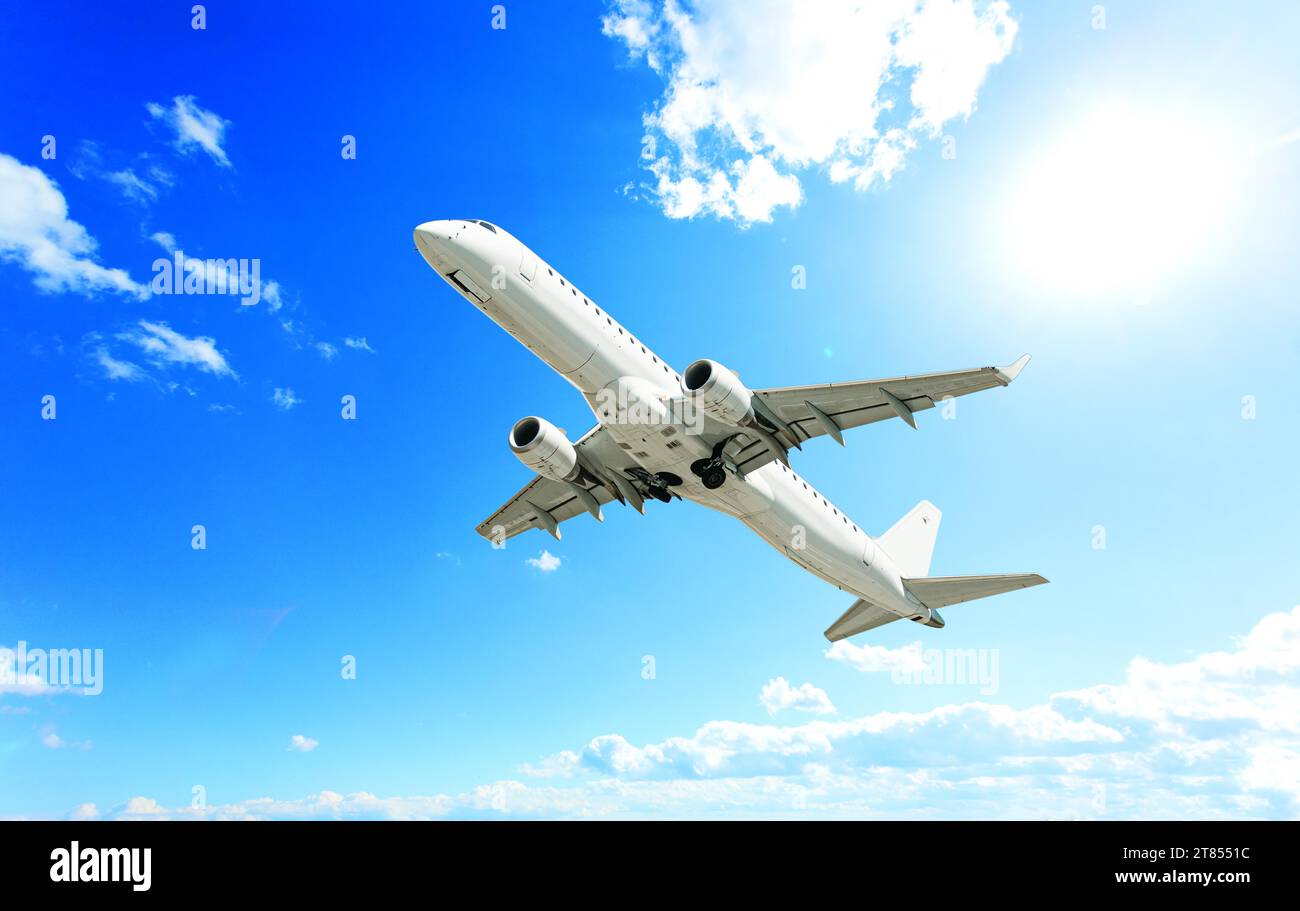 the passenger plane takes off on blue sky background with tiny clouds ...