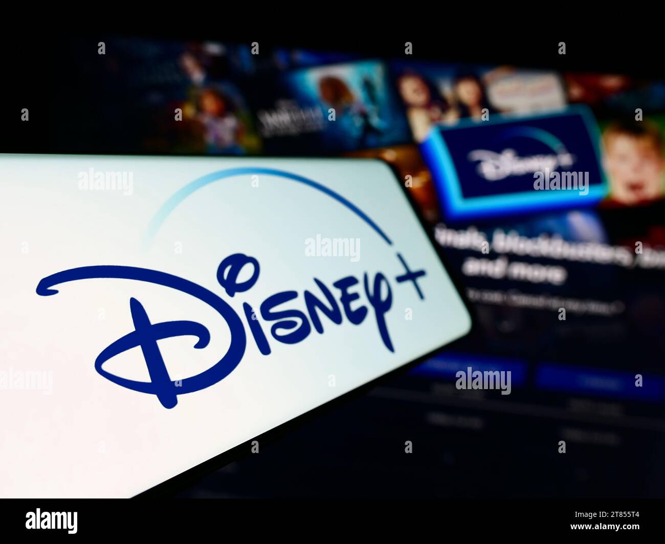 Cellphone with logo of American video-on-demand streaming service Disney Plus in front of business website. Focus on left of phone display. Stock Photo