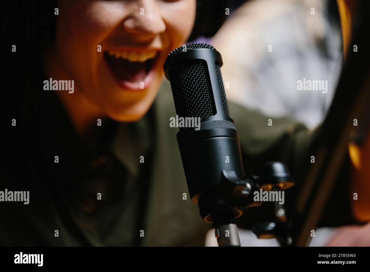 Close-up, dubbing actor or radio host speaking into a microphone. Stock Photo