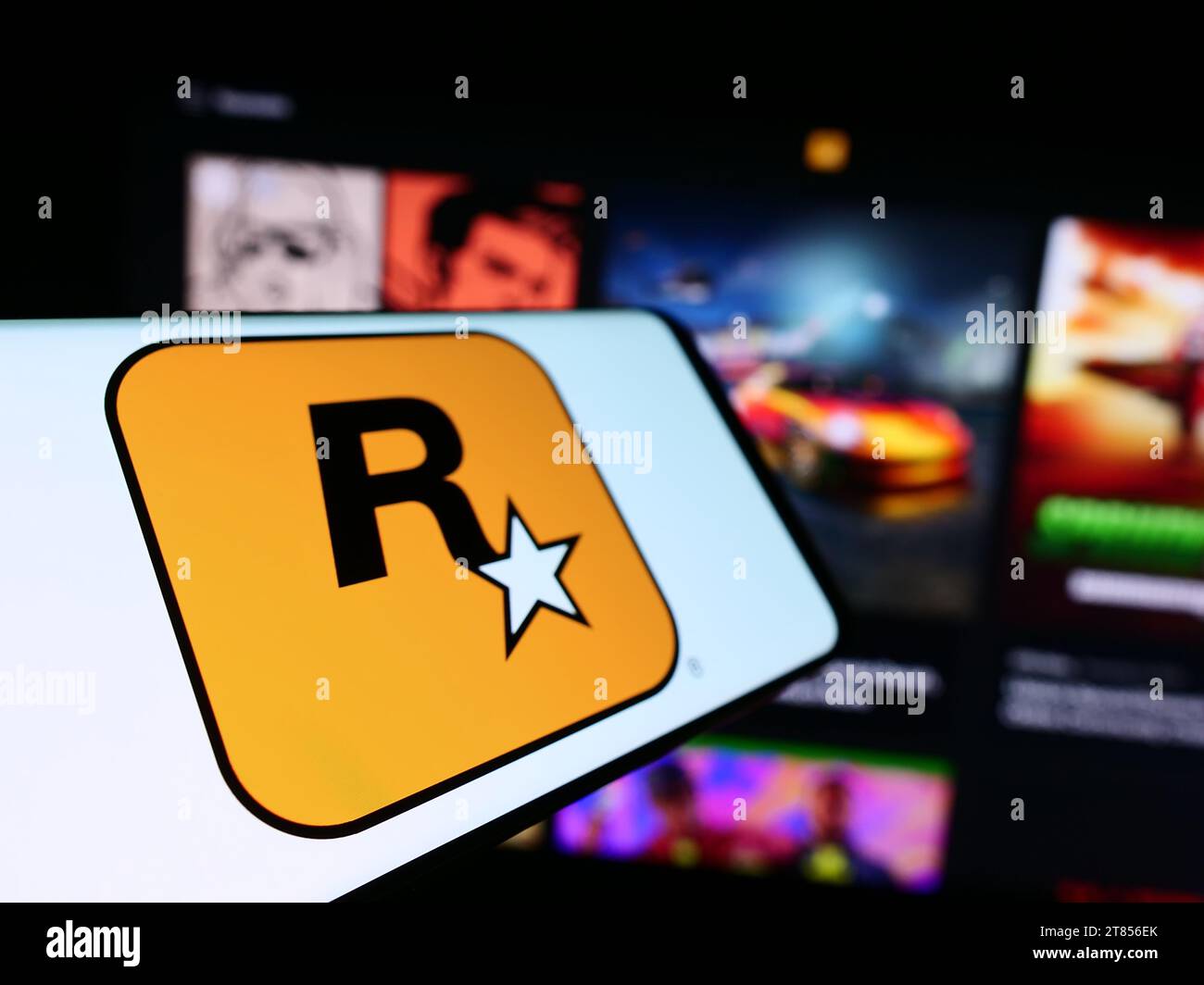 Mobile phone with logo of American video game publishing company Rockstar Games Inc. in front of website. Focus on left of phone display. Stock Photo