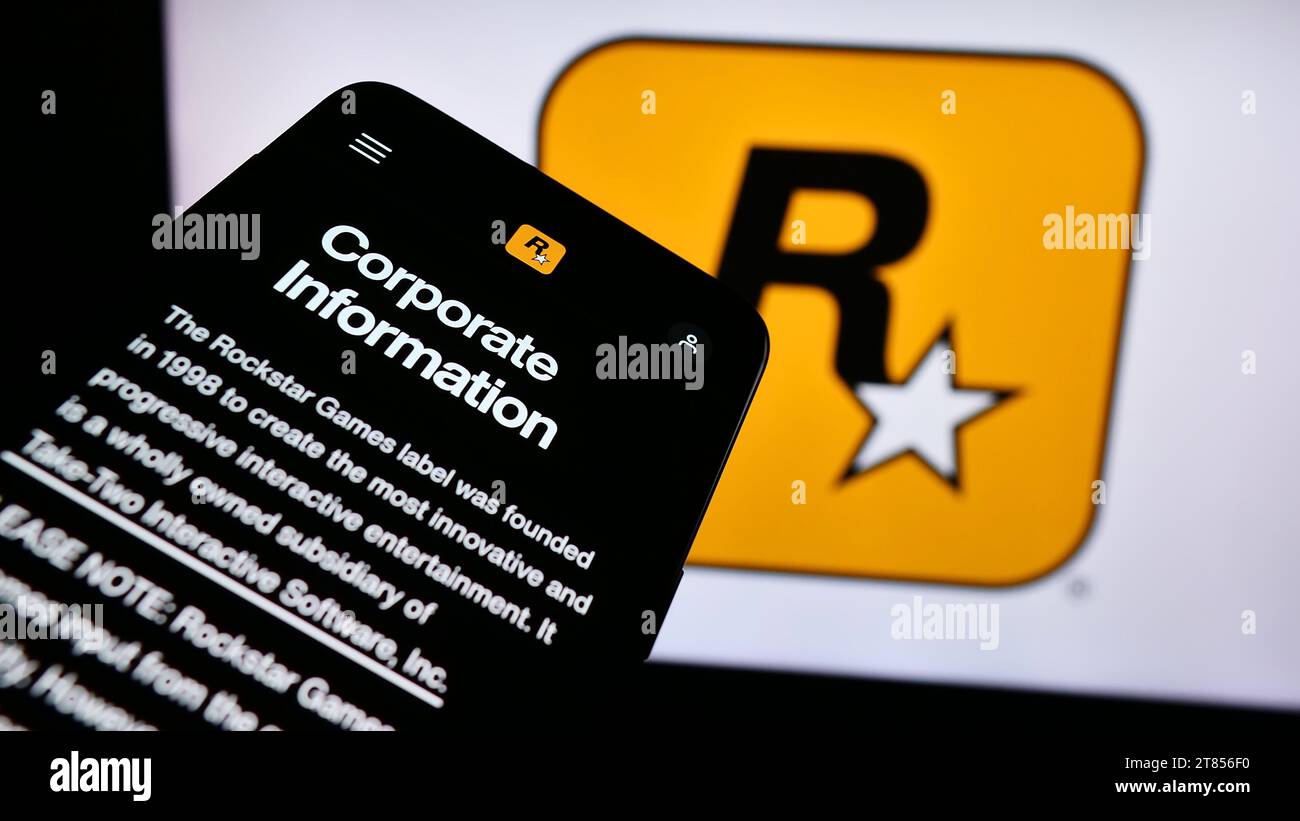 Smartphone with website of US video game publishing company Rockstar Games Inc. in front of business logo. Focus on top-left of phone display. Stock Photo