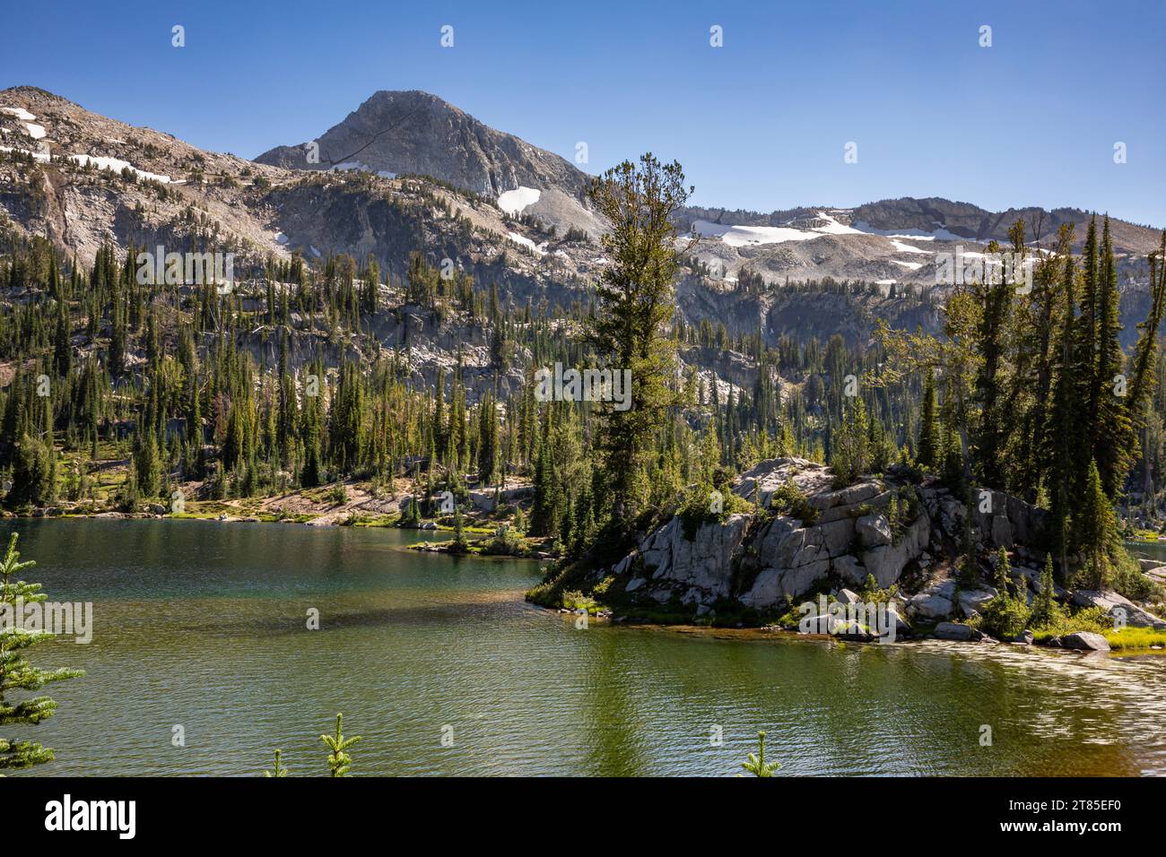 OR02790-00...OREGON - Granite outcrop with trees in Moccasin Lake and Eagle Cap beyond; Eagle Cap Wilderness. Stock Photo