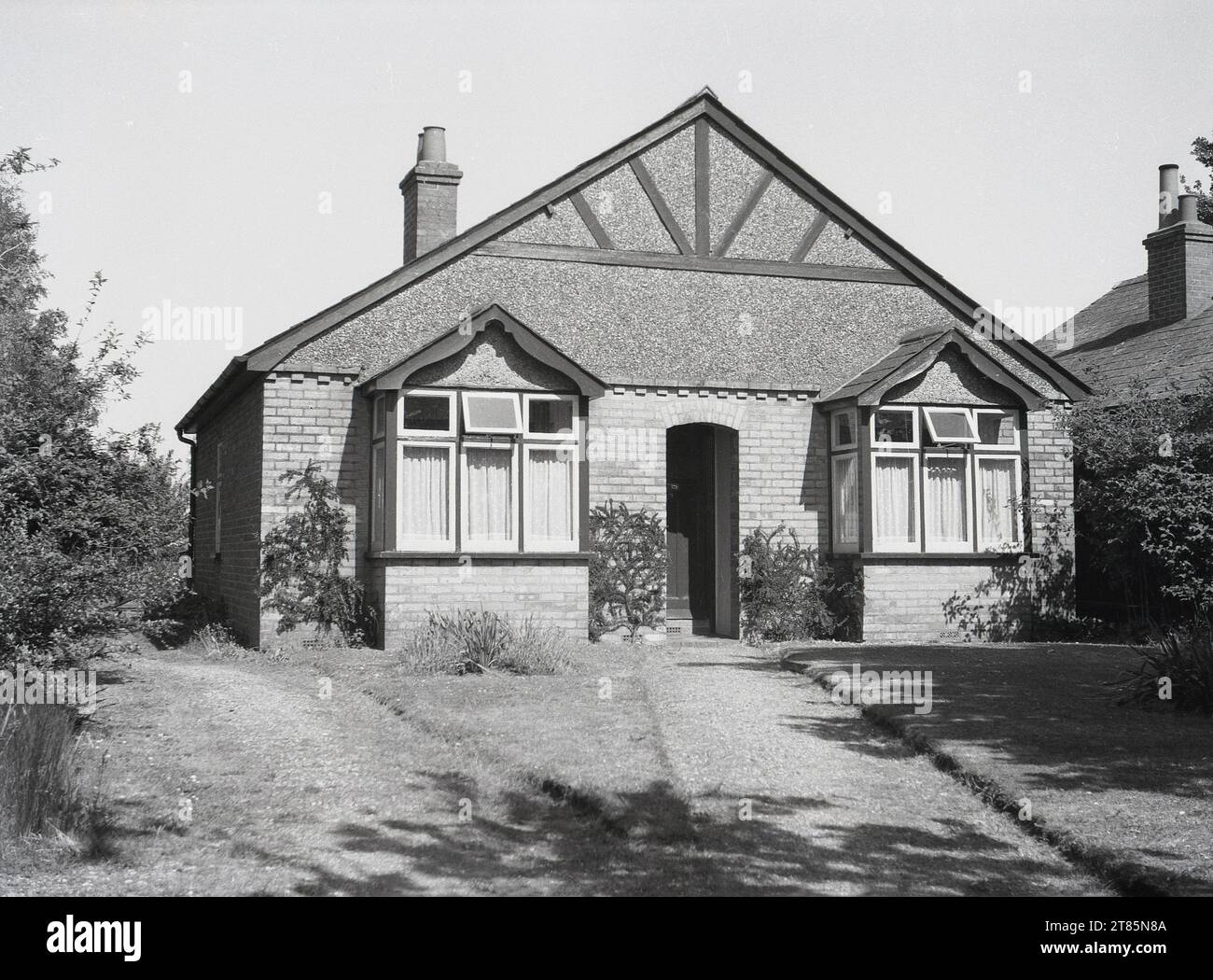 1950s, historical, front view of a bungalow of the era, brick built with pebble-dash covered top exterior, with sloping roof structure, England, UK. Stock Photo