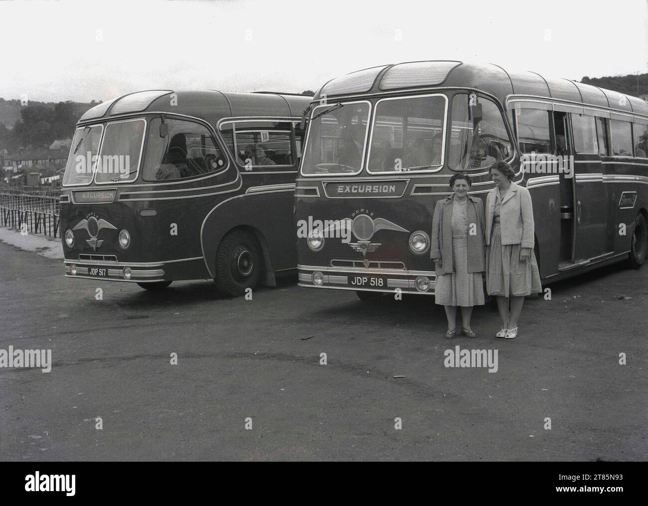 1950s, historical, two ladies standing by AEC 'Duple' excursion motor coaches of the era, operated by Smyth's, England, UK. Before overseas package holidays, in Britain people went to their holiday destination by coaches and buses and so the 1950s are known as the 'golden age' of coach travel. Formed in 1919, Duple was a coach and bus bodybuilder known for its distinctive stylish designs, many produced for the Associated Equipment Company (AEC) a British vehicle manufacturer of the era. Stock Photo