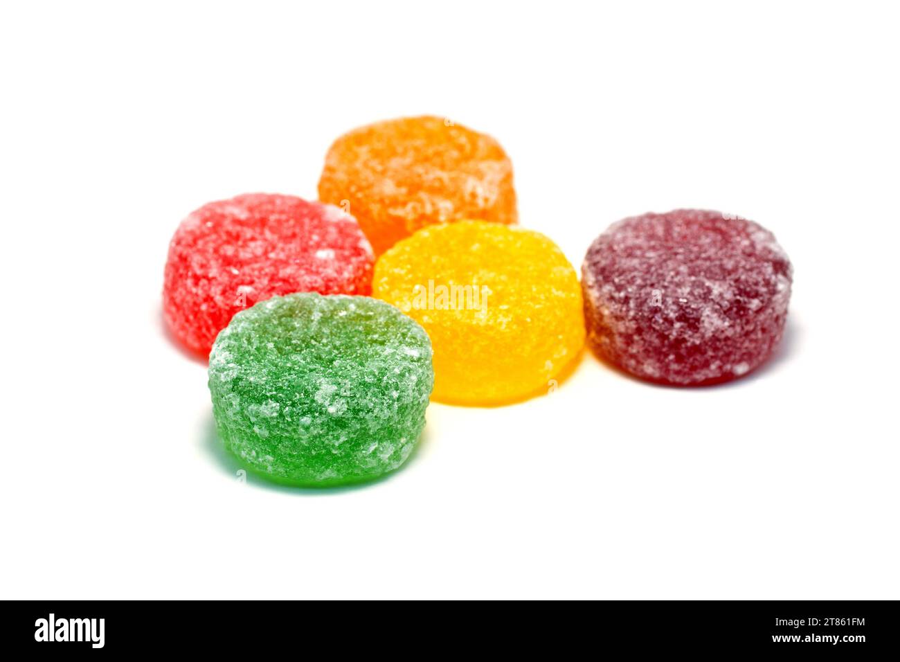 Close up of a selection of colourful fruit pastilles including red, orange, yellow, green and violet, shot against a white background. Stock Photo