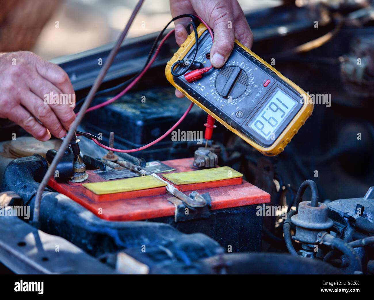 car electrical maintenance, electrician with a meter measuring voltage