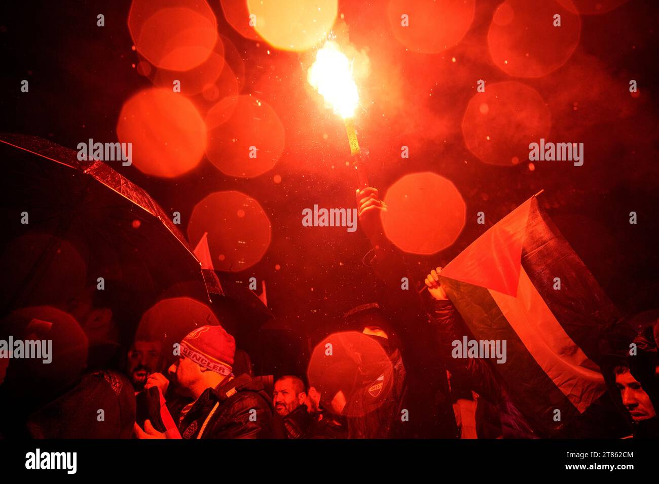 People light flares under heavy rain during a proPalestinian protest