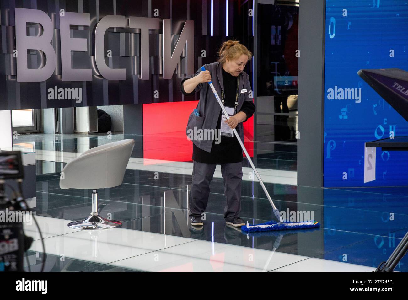 Moscow, Russia. 18th of November, 2023. A woman cleans a studio of the informational television news program Vesti of Russia TV channel at the National Expo 'Russia' on the territory of the exhibition complex VDNKh in Moscow, Russia. The banner reads 'Russia Vesti' Stock Photo