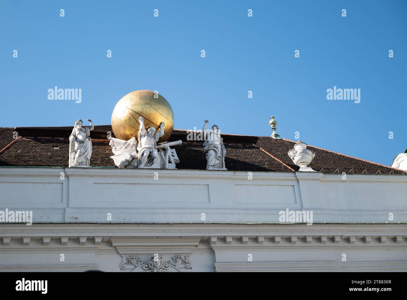 Vienna, Austria 29 September 2023. Atlas carrying golden globe - statues on the roof of Hofburg imperial palace Stock Photo