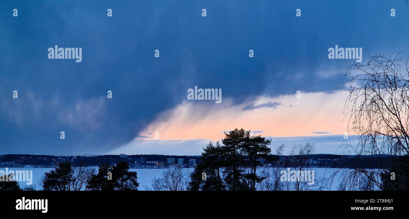 Snow clouds over a lake in Tampere, Finland in the beginning of March 2023. Stock Photo