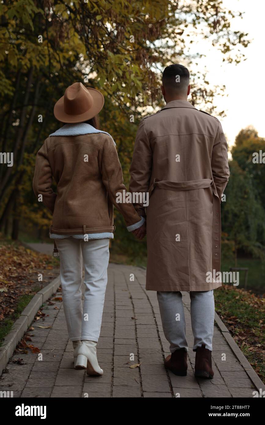 Happy young couple walking in autumn park, back view Stock Photo - Alamy