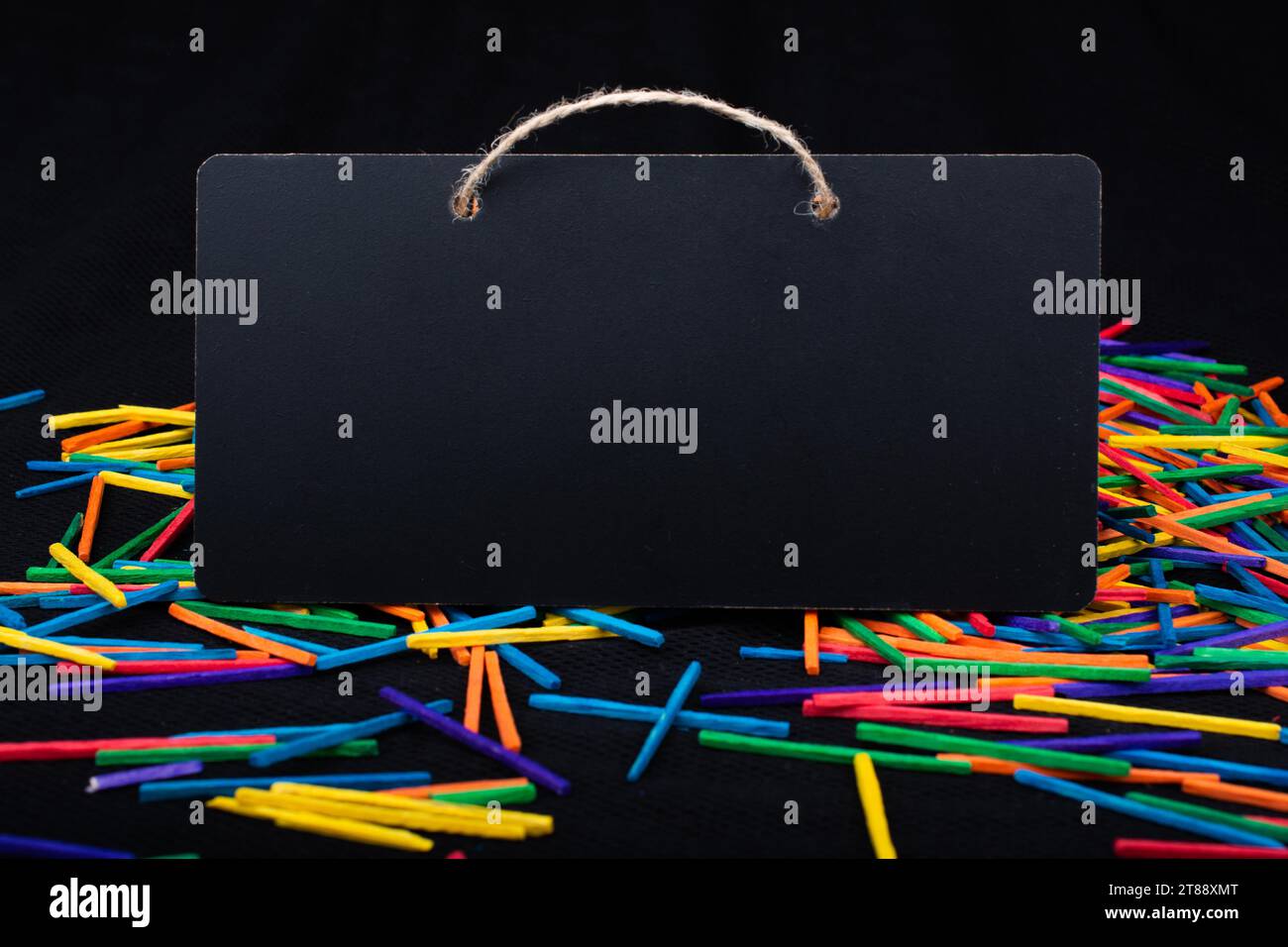 Rectangular shaped black notice board on colorful sticks on black Stock Photo