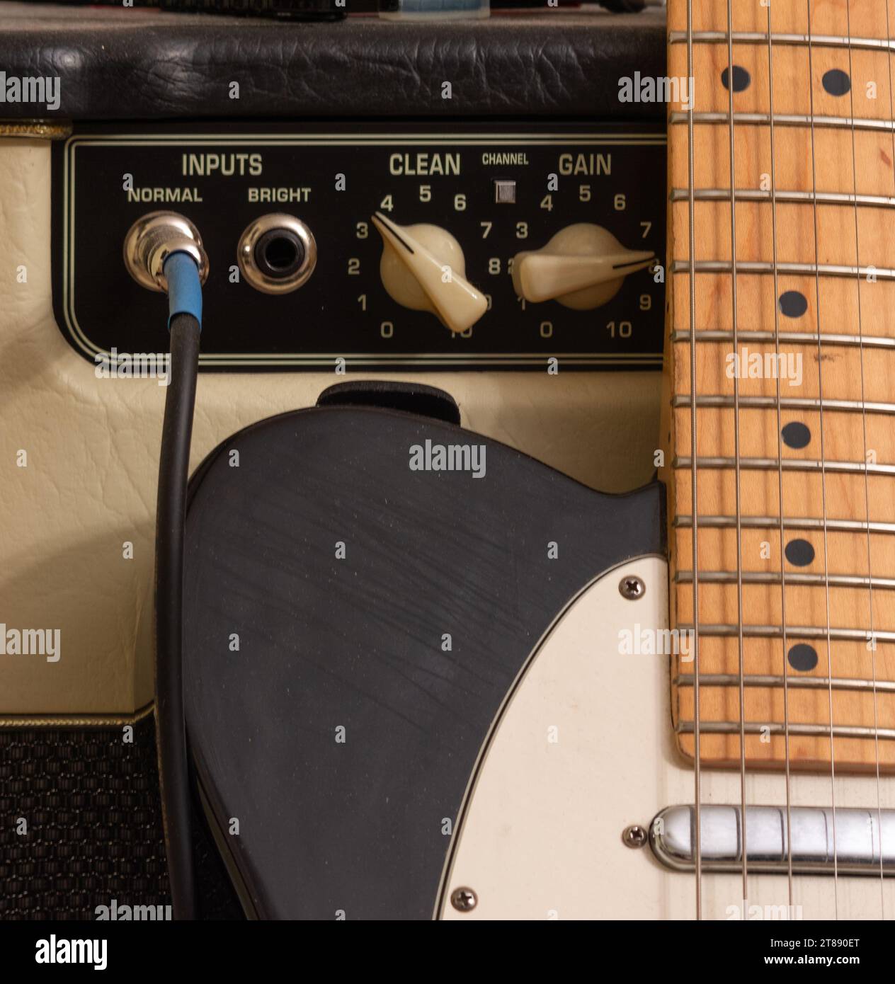 Black and white electric guitar with tube amplifier and cord Stock