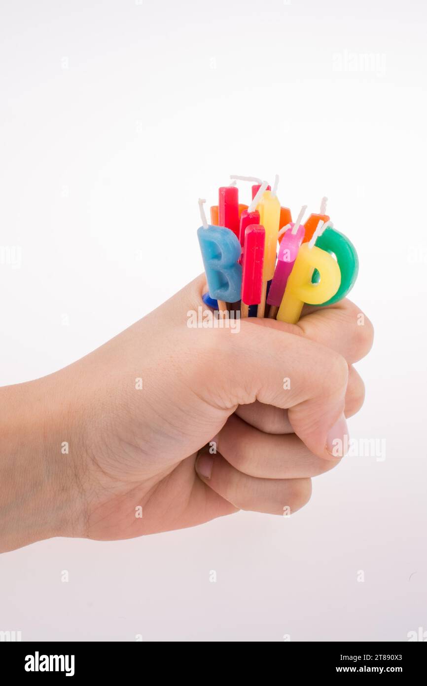 Hand holding letters made of candles on sticks Stock Photo - Alamy