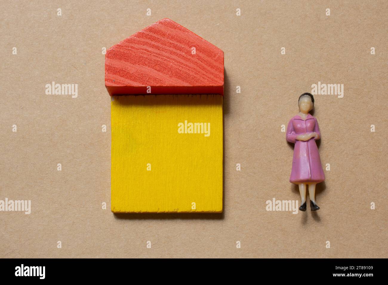 Woman figurine by House from wooden blocks as concept of buying, selling, renting real estate, building and eco style Stock Photo