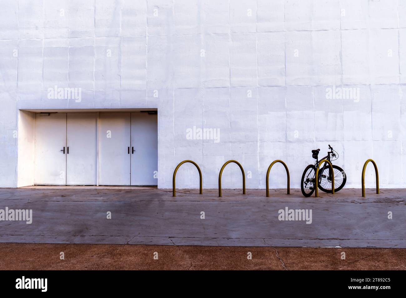 bicicleta estacionada no bicicletário ao lado da saída de emergência de um teatro, com uma grande área de copy space no Brazil Stock Photo