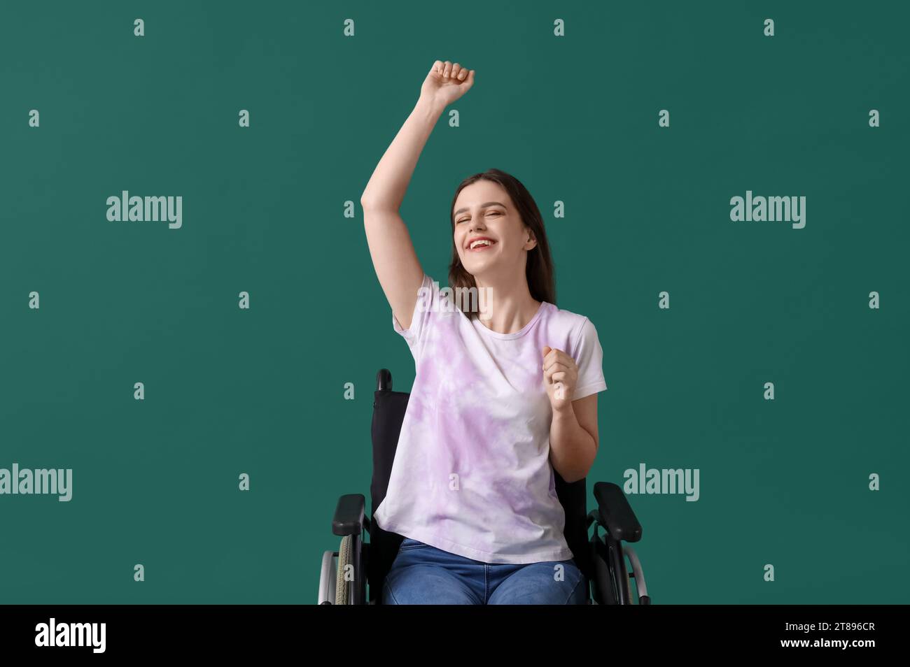 Happy young woman in wheelchair on green background Stock Photo - Alamy