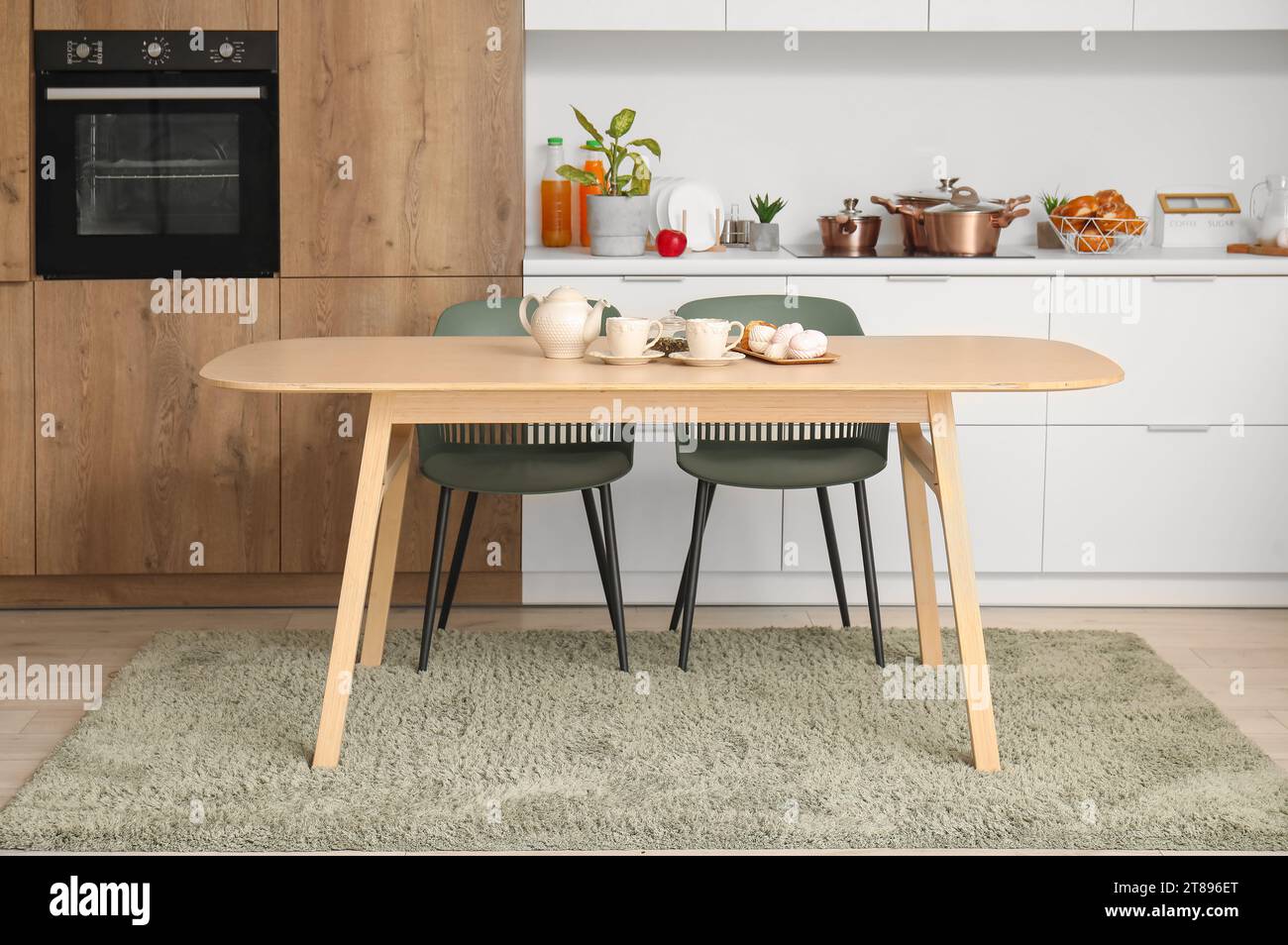 Interior of modern kitchen with wooden dining table Stock Photo - Alamy