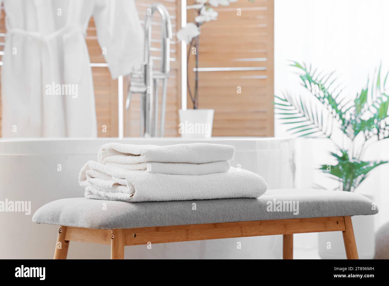 Interior of light bathroom with grey bench and bathtub Stock Photo - Alamy
