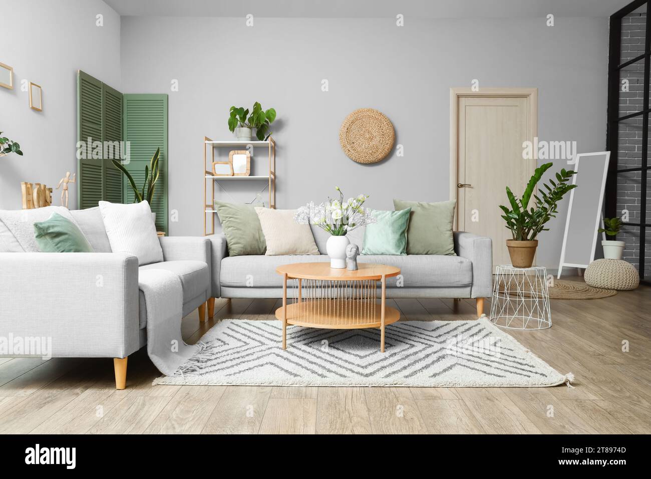 Interior of modern living room with grey sofas, flower vase on coffee