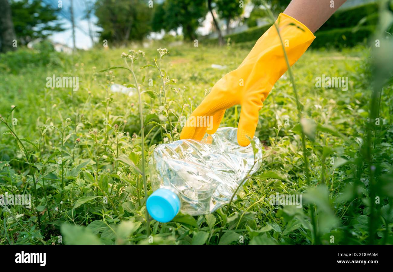 Volunteer teenage boys are picking up plastic bottle waste at public parks for recycling, Reuse, and waste management concepts. Stock Photo