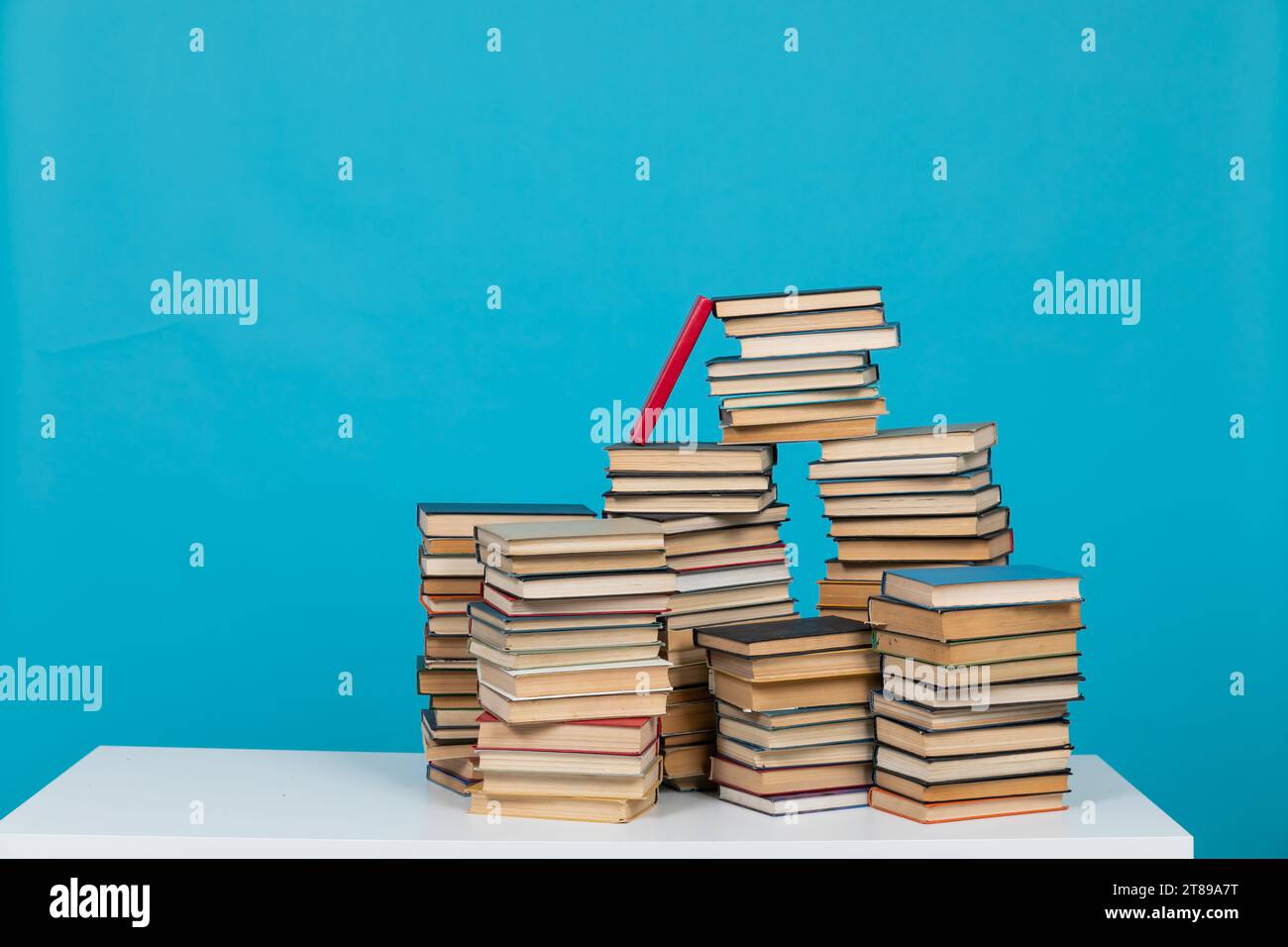 science of knowledge reading many books in stacks in the library on a ...