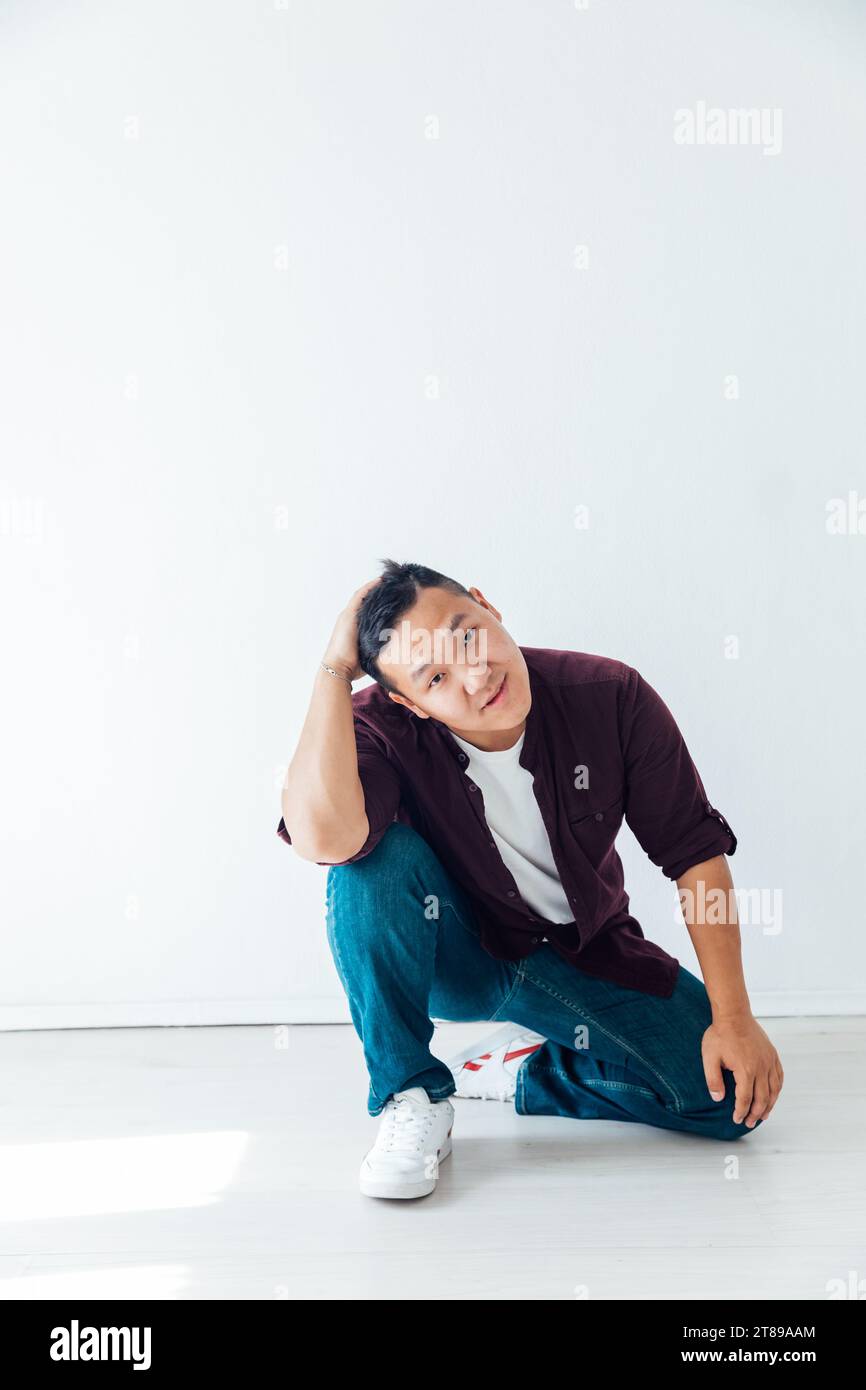 a man sits and holds his head in a bright room Stock Photo - Alamy