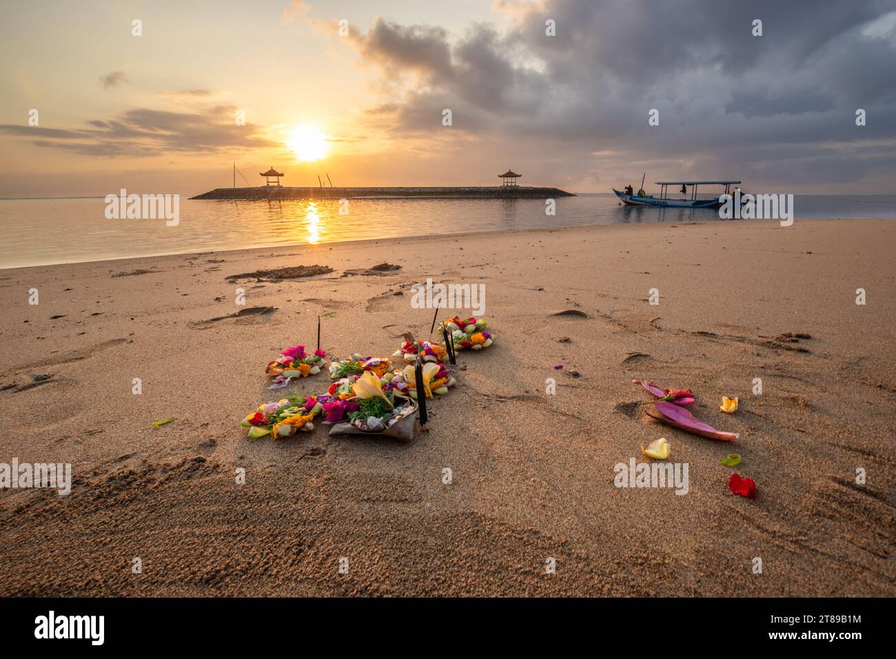 Sunrise at the sandy beach of Sanur. Temple in the water. Offerings by the sea on the beach. Hindu faith in Sanur on Bali. Dream island and dream Stock Photo
