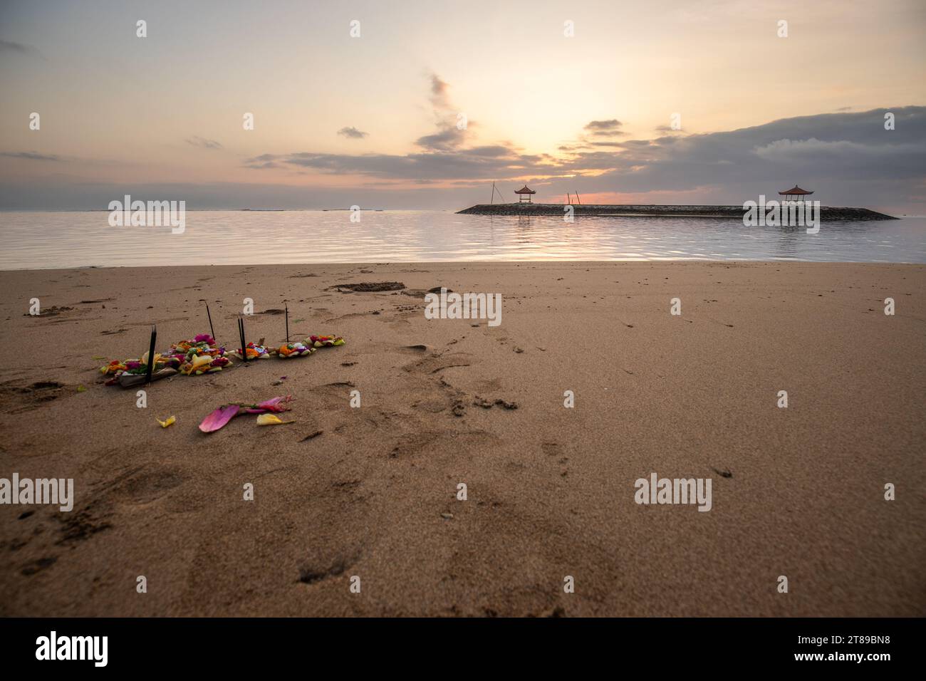 Sunrise at the sandy beach of Sanur. Temple in the water. Offerings by the sea on the beach. Hindu faith in Sanur on Bali. Dream island and dream dest Stock Photo
