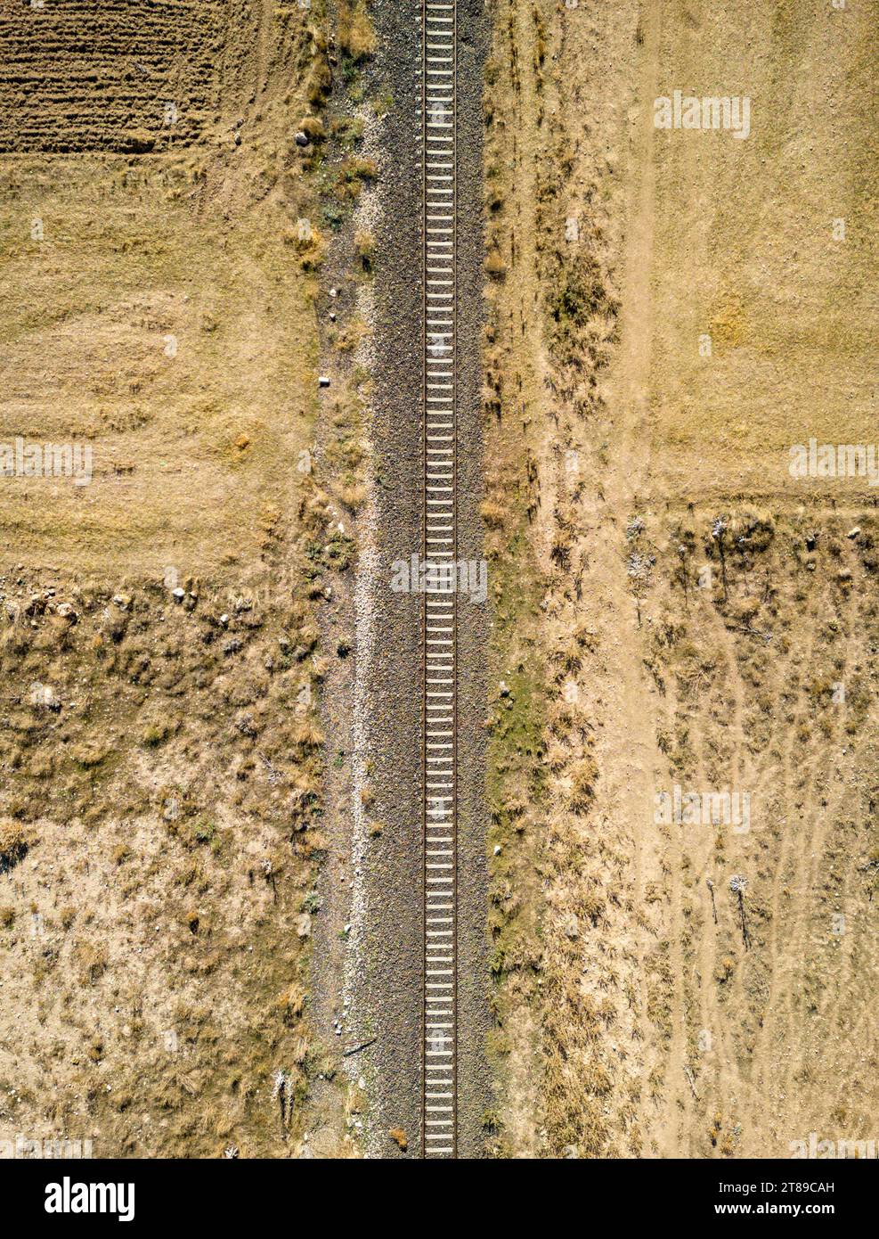 Top view of the train track passing through the arid land, taken with a ...