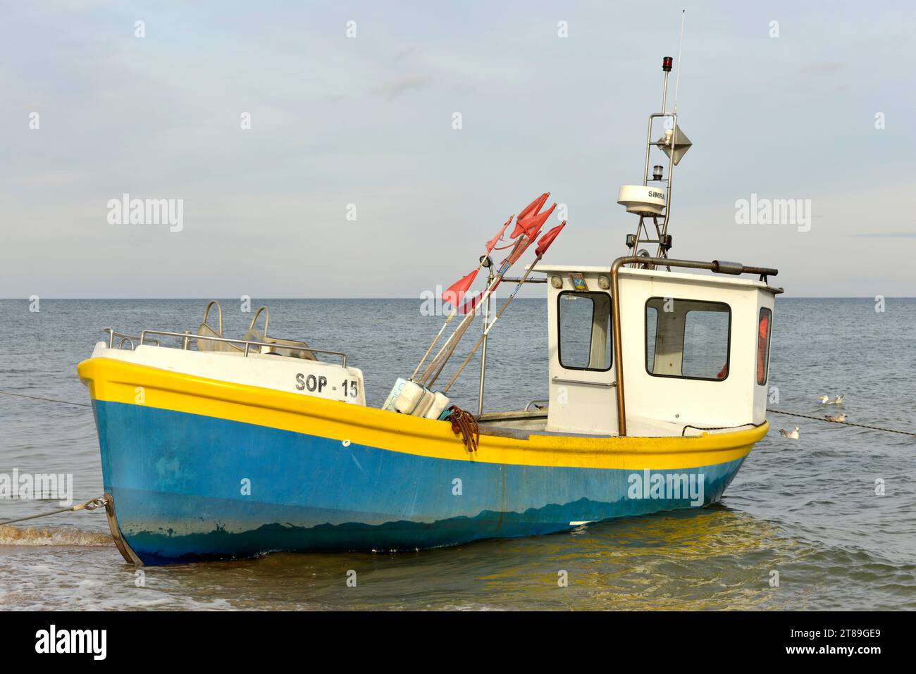 Beached small blue fishing motorboat registered in Sopot in shallow sea water, Baltic Sea, Sopot, Poland, Europe, EU Stock Photo