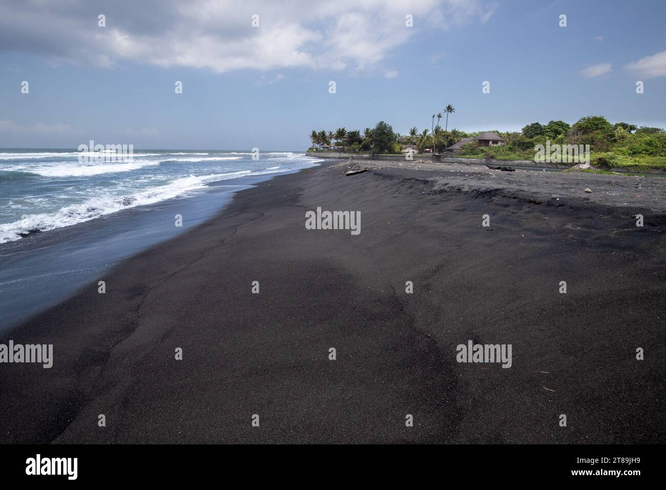 Black sand beach in Bali, natural with temples, boats (jukung) and waves at sunrise. Tropical environment in Indonesia in the morning Stock Photo