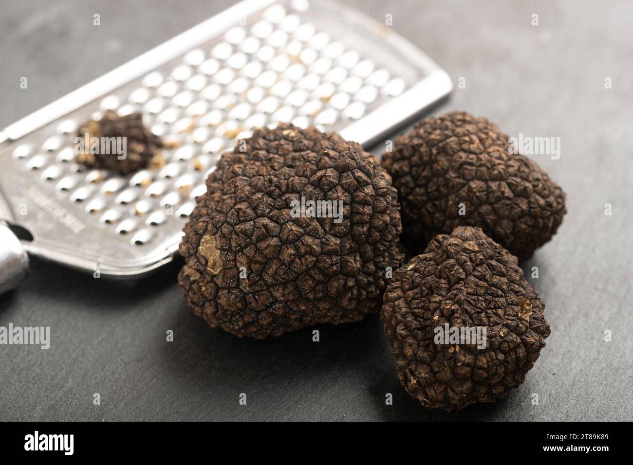 A Group of Exquisite Truffles Paired with a Grater for Culinary Stock Photo