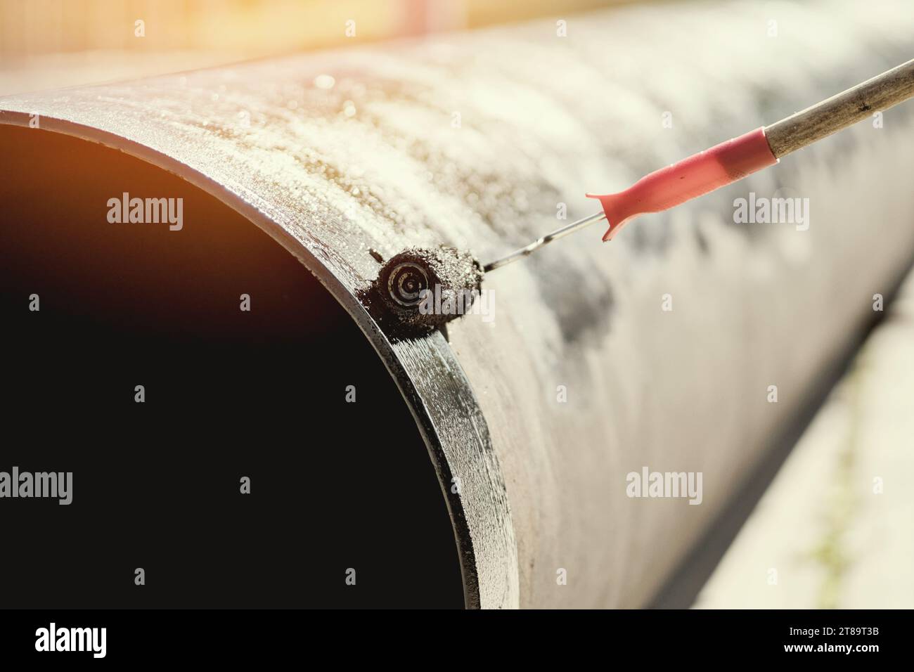 Metal pipe is painted with paint roller with black paint or bitumen. Protection of metal pipes