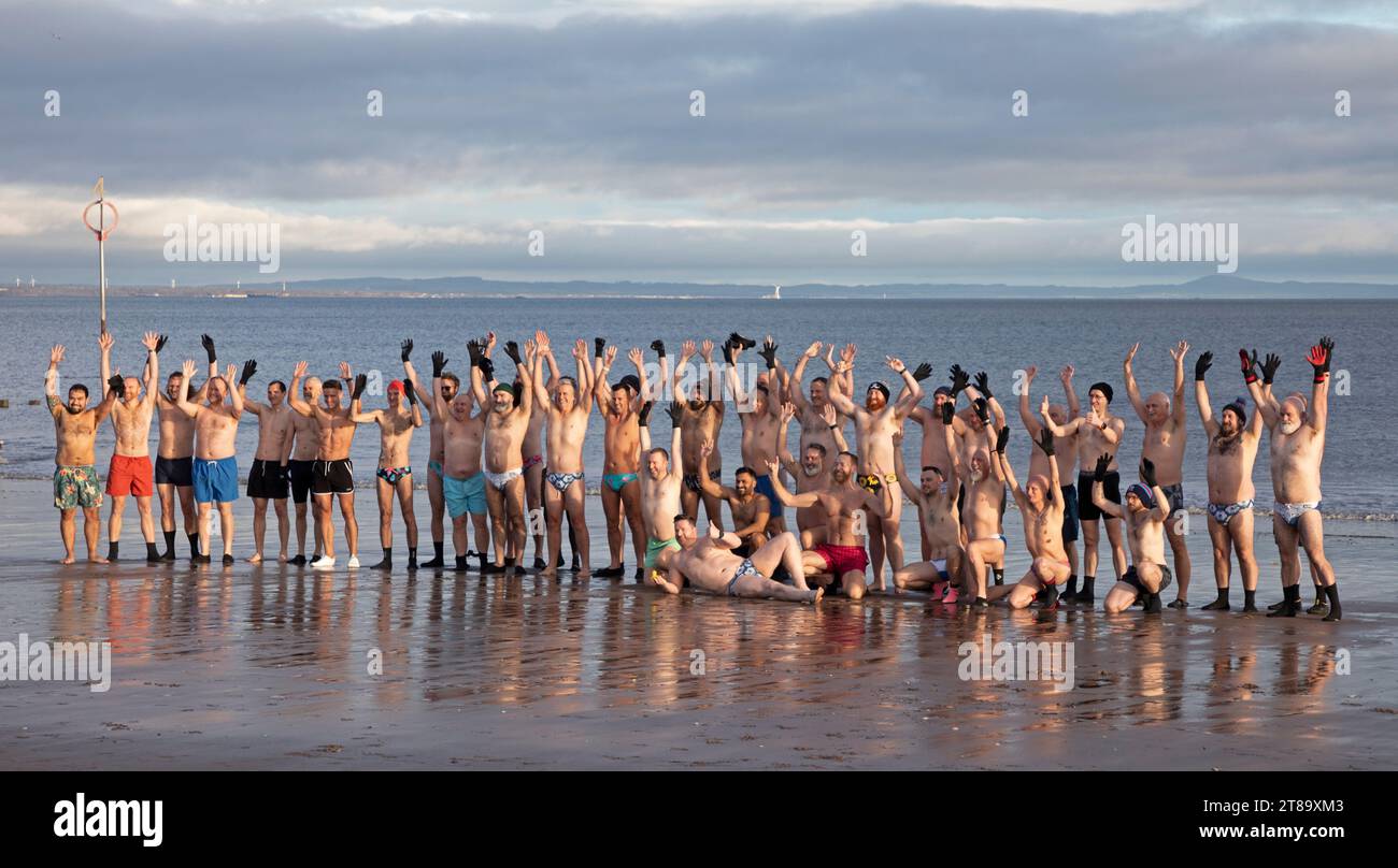 Portobello, Edinburgh, Scotland, UK. 19th November 2023. Mild November morning for those out to exercise in the sunshine, temperature 12 degrees centigrade. Pictured: The Blueballs group take theie regular dip in the Firth of Forth, created to assist men with their mental health and well being. Credit: Scottiscreative/alamy live news. Stock Photo