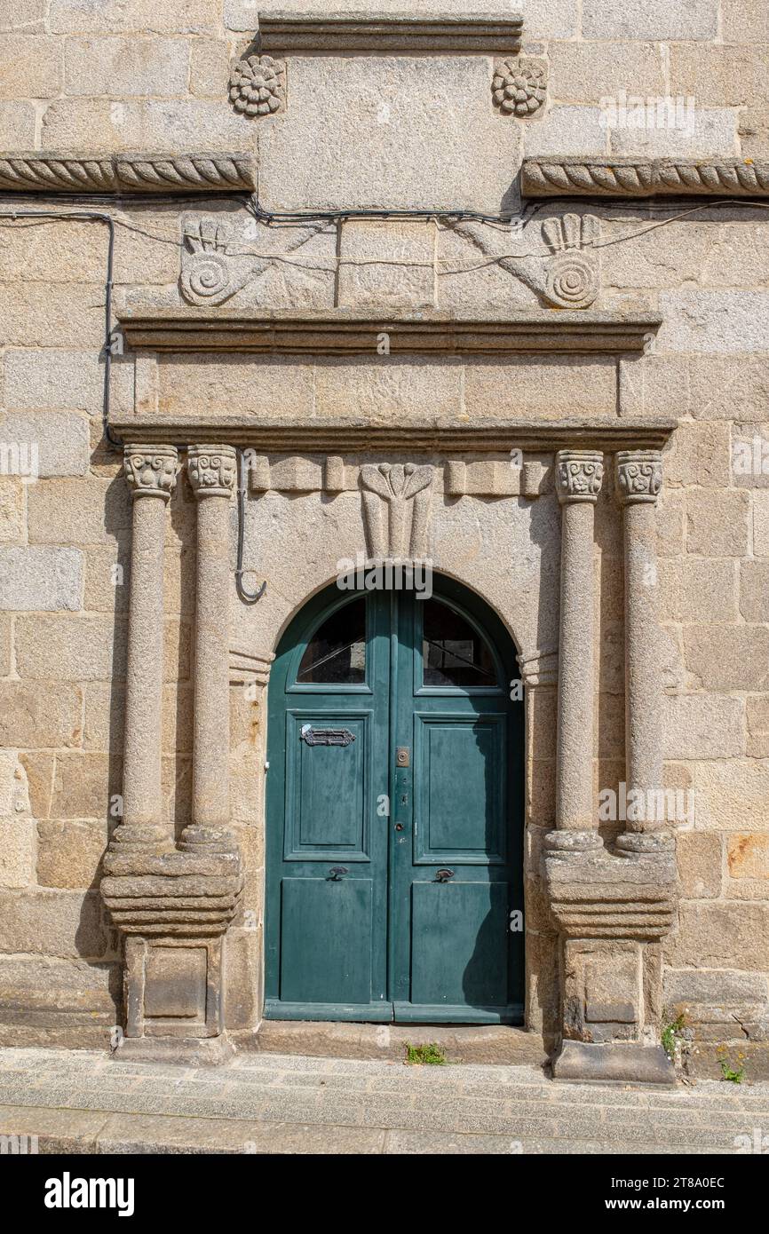 An heritage Renaissance stone and wood door in Quintin, Brittany, France taken on a sunny summer day with no people Stock Photo