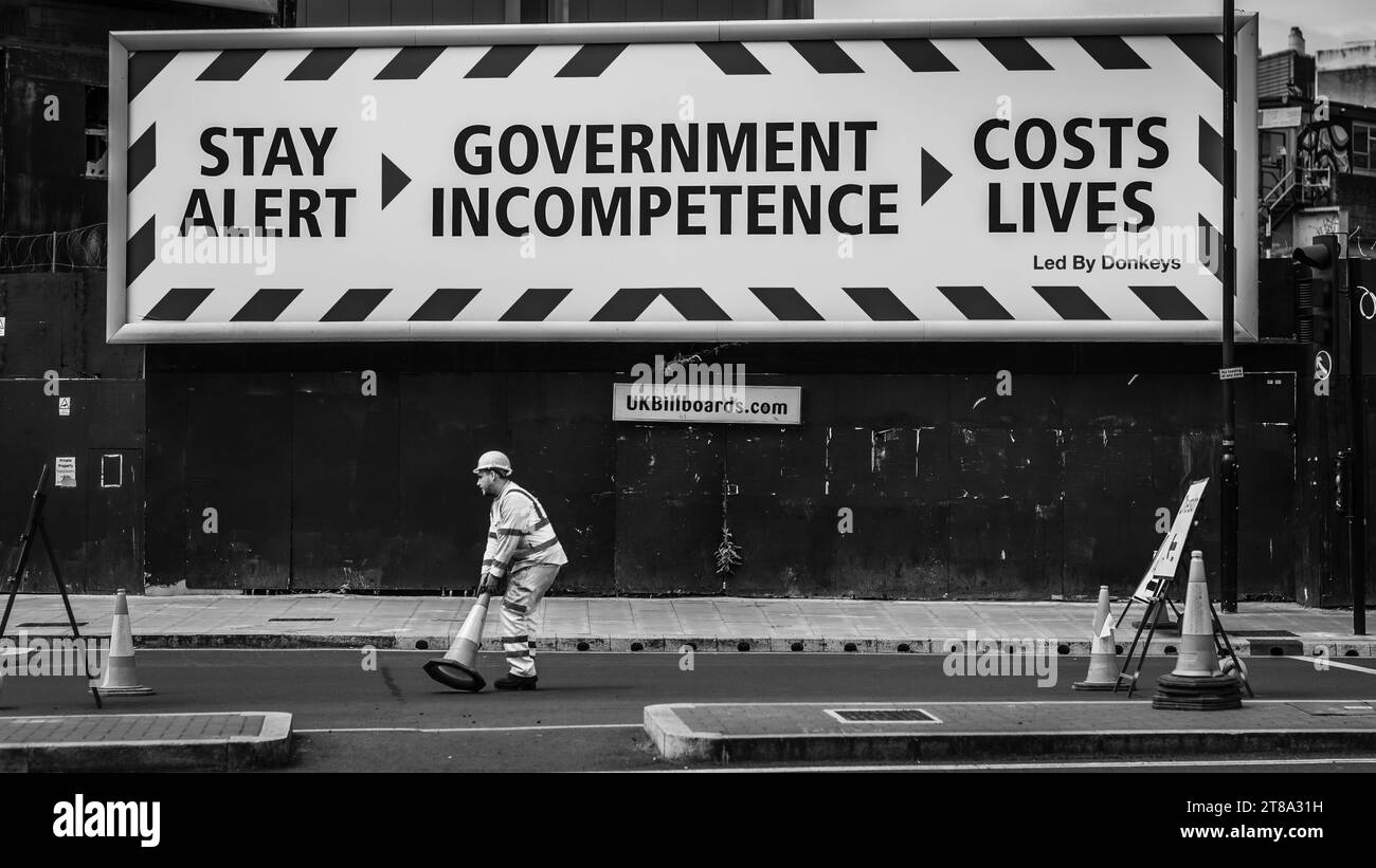 A black and white image of a lone worker in a deserted London during the Lockdown. Stock Photo