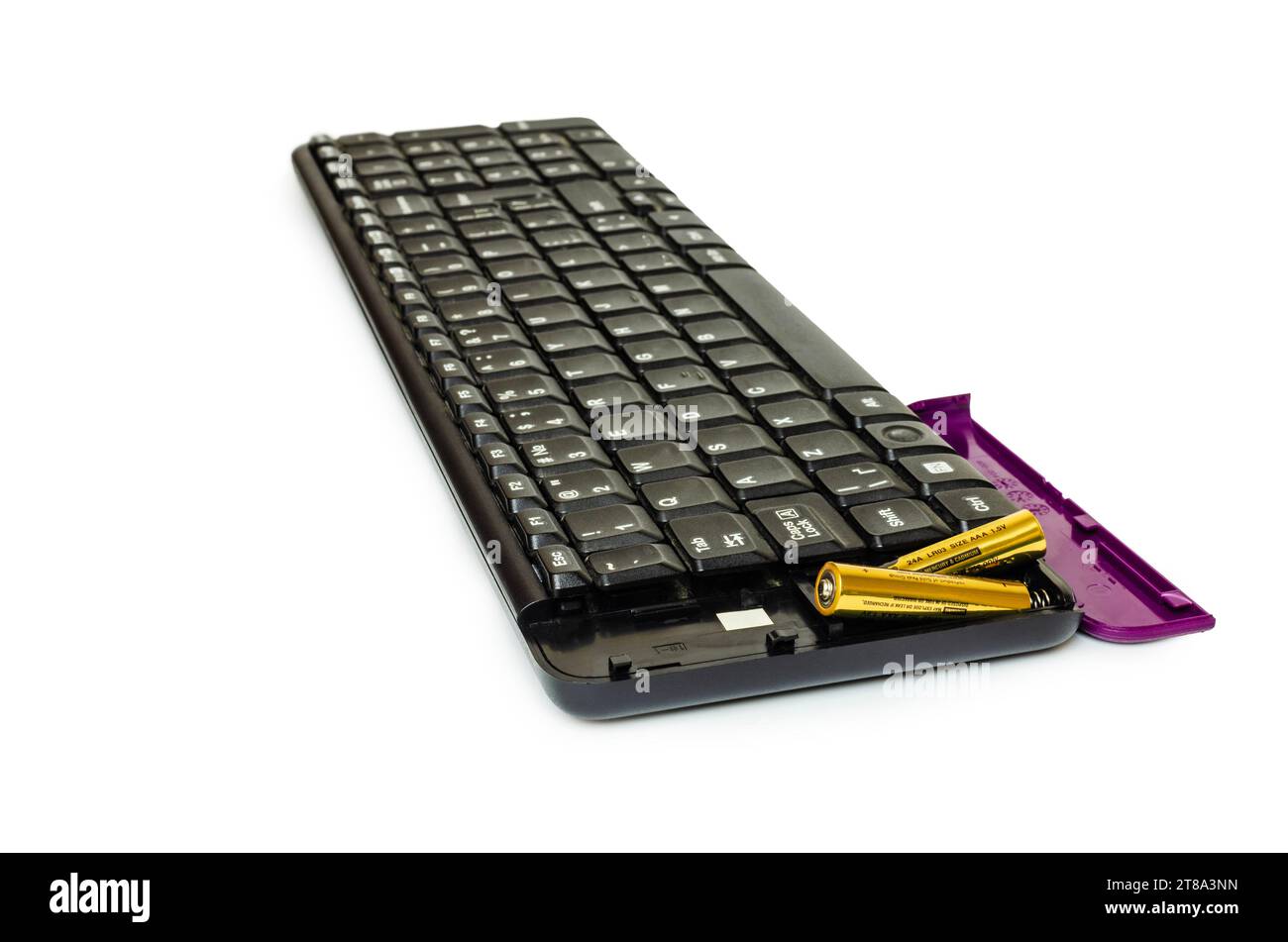 Black wireless keyboard with purple cover and two batteries. Background white Stock Photo