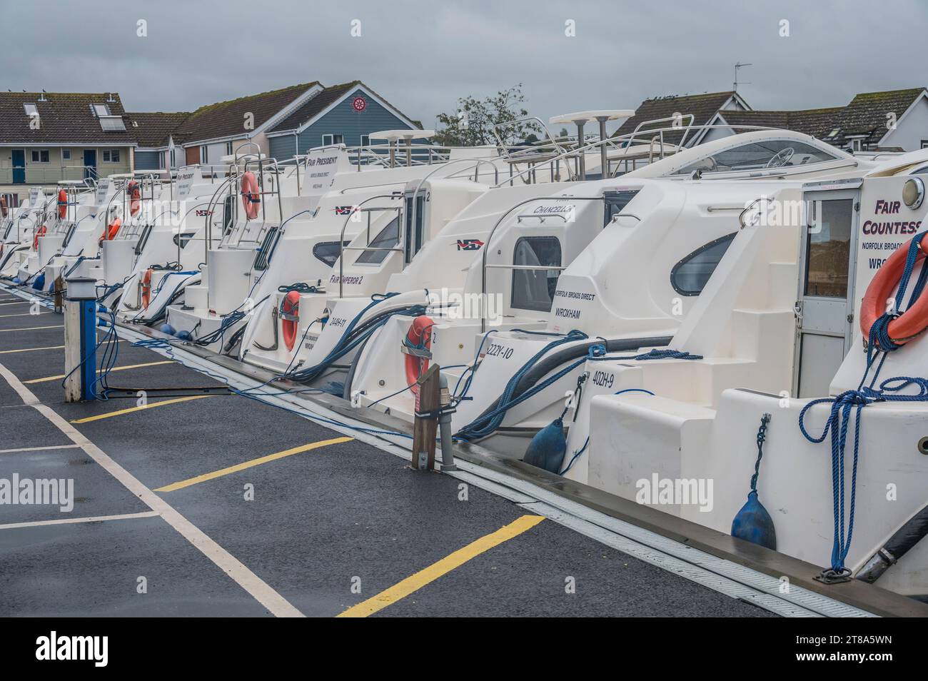 The image is of pleasure boat cruiser boats for hire at the Wroxham small boat marina in the Norfolk town of Wroxham on the Norfolk Broads Stock Photo