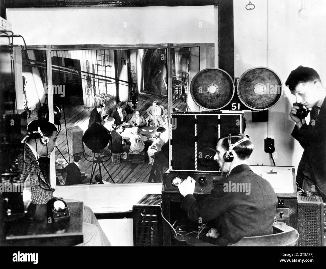 Sound Engineers in glass-panelled booth operating the new British Acoustic sound recording apparatus with below Director VICTOR SAVILLE directing a scene with JESSIE MATTHEWS EDMUND GWENN and JOHN GIELGUD during filming of THE GOOD COMPANIONS 1933 director VICTOR SAVILLE novel J.B. Priestley Gaumont British Film Corporation / Welsh-Pearson publicity for British Acoustic Films Ltd. Stock Photo