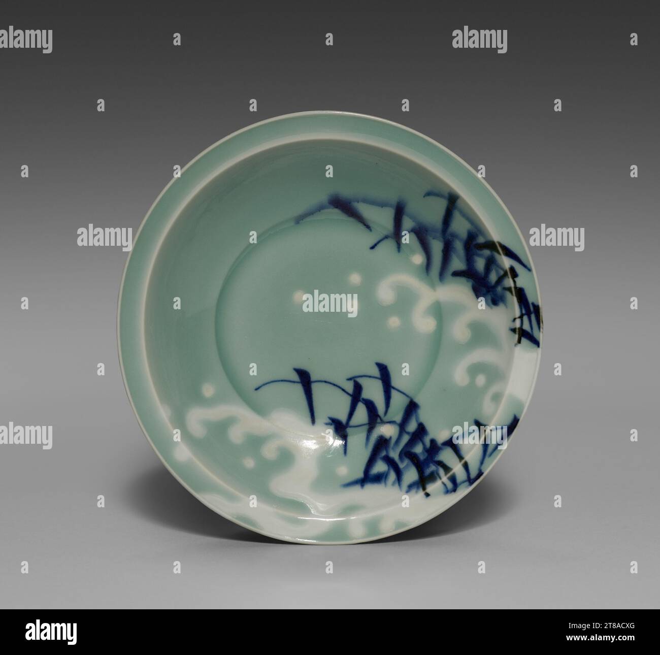 Small Dish (Kozara) with Everted Rim and Wave and Reed Design, late 1600s. Japan, Edo period (1615–1868). Porcelain with underglaze blue and celadon (Hizen ware, Nabeshima type); diameter: 15.2 cm (6 in.). Stock Photo
